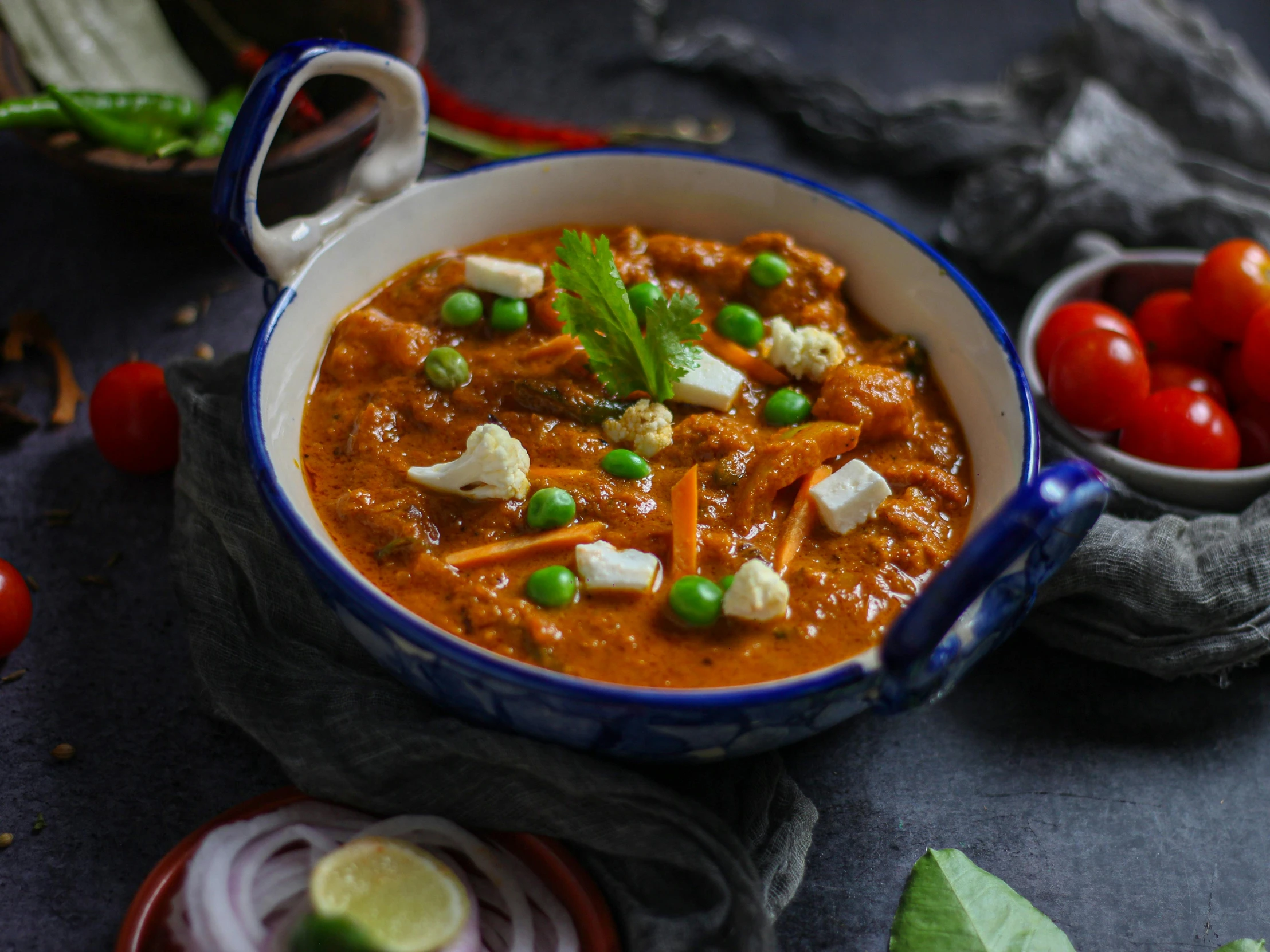 a close up of a bowl of food on a table, by Julia Pishtar, desi, background image, stew, 3 4 5 3 1