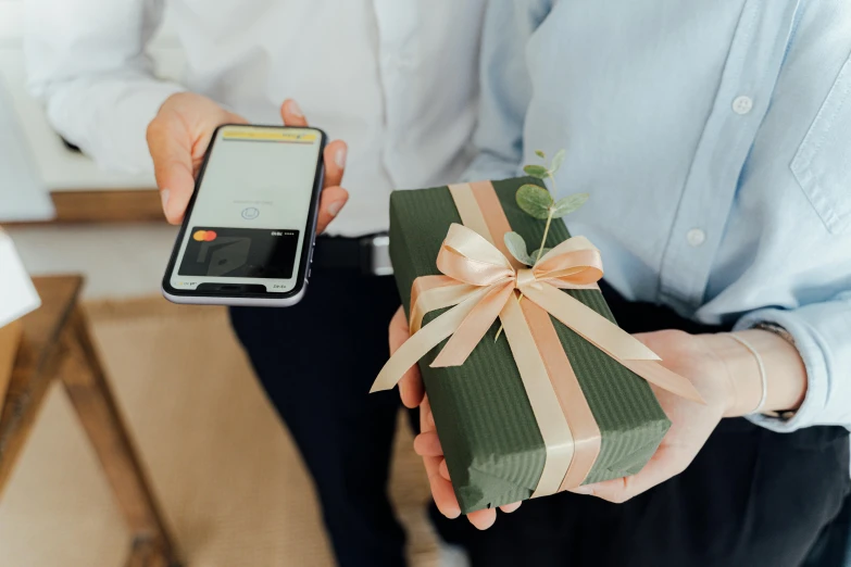 a person holding a present and a cell phone, product image, bogna gawrońska, thumbnail, cardboard