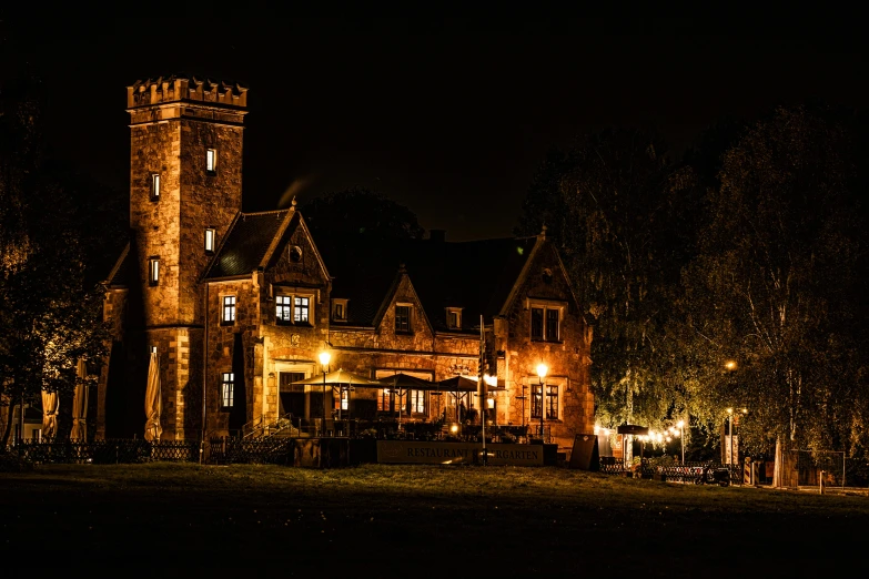 a castle like building lit up at night, a photo, by Peter Churcher, victorian manor, restaurant exterior photography, thumbnail, shot on sony a 7