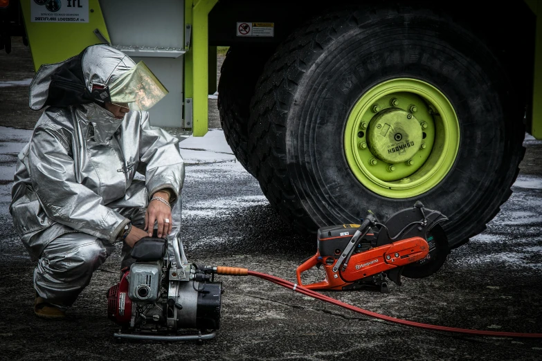 a man using a chainsaw to cut a tire, a portrait, by Anato Finnstark, pexels contest winner, hyperrealism, wearing hi vis clothing, robot made of truck parts, focus on anti-g flight suit, contain