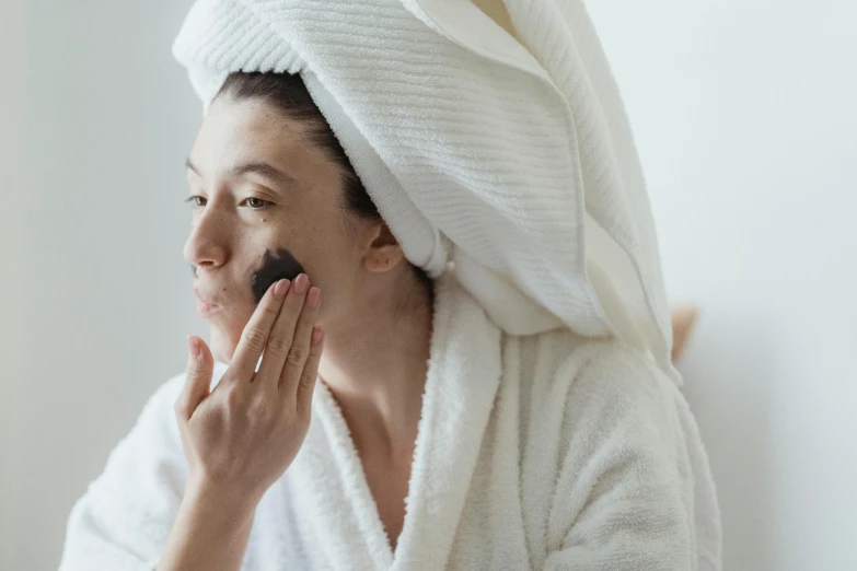 a woman with a towel on her head shaving her face, by Emma Andijewska, trending on pexels, renaissance, black mask, wearing a grey robe, manuka, thumbnail