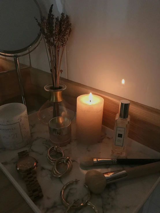 a candle sitting on top of a counter next to a mirror, a still life, inspired by Elsa Bleda, trending on pexels, ☁🌪🌙👩🏾, low quality photo, flatlay, night photo