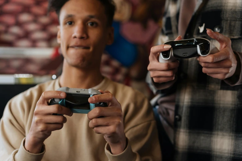 a man holding a video game controller next to another man, trending on pexels, avatar image, uk, college, high quality image