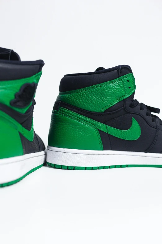 a pair of green and black sneakers on a white surface, an album cover, by Gavin Hamilton, trending on unsplash, air jordan 1 high, ( side ) profile, panels, glowing green