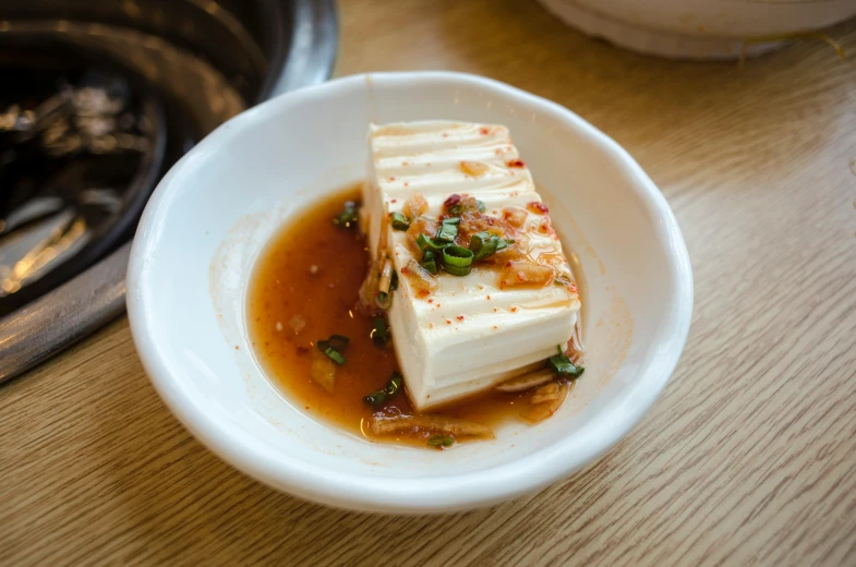 a close up of a bowl of food on a table, unsplash, mingei, mapo tofu cartoon, square, jelly, white