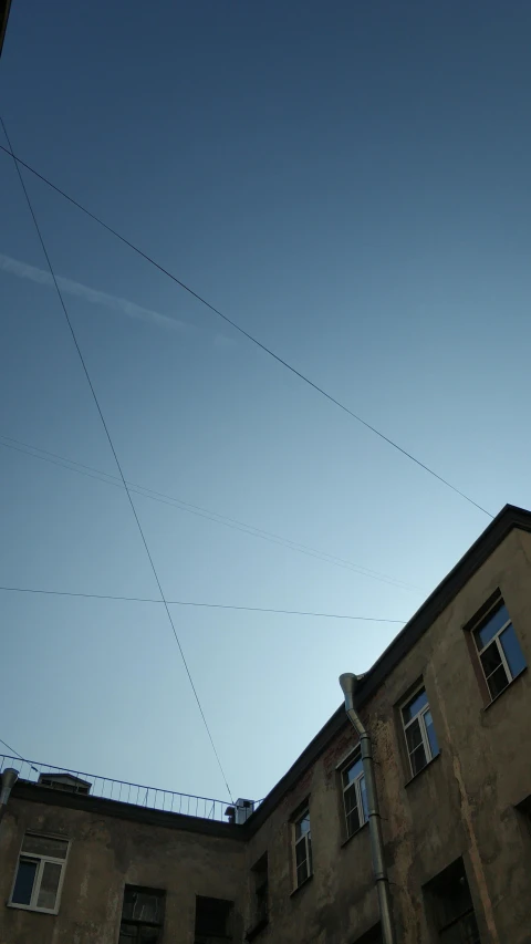 a man riding a skateboard up the side of a building, inspired by Alexander Rodchenko, unsplash, cable wires, in legnica, panorama view of the sky, :: morning