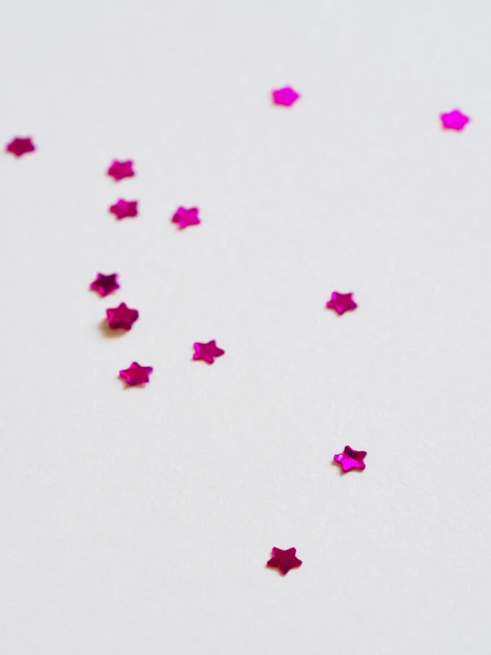 pink stars are scattered on a white surface, by Arabella Rankin, pexels, miniature product photo, cyber embellishment, smol, trending on vsco