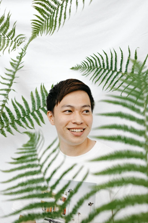 a man that is standing in front of some plants, inspired by Joong Keun Lee, sumatraism, headshot profile picture, in front of white back drop, fern, looking happy