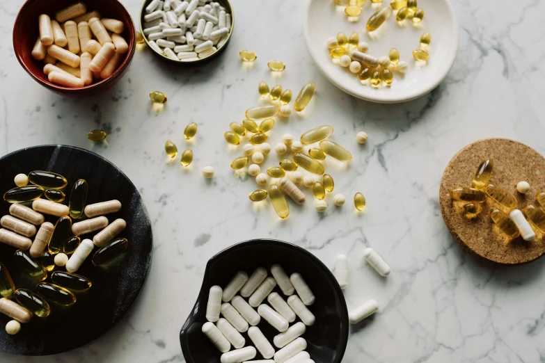 a table topped with lots of different types of pills, by Julia Pishtar, trending on pexels, natural materials, white and yellow scheme, “ iron bark, on grey background