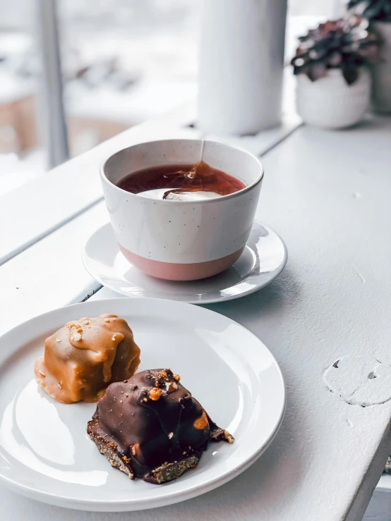 a white plate topped with donuts next to a cup of tea, plate of borscht, smothered in melted chocolate, cold as ice! 🧊, thumbnail