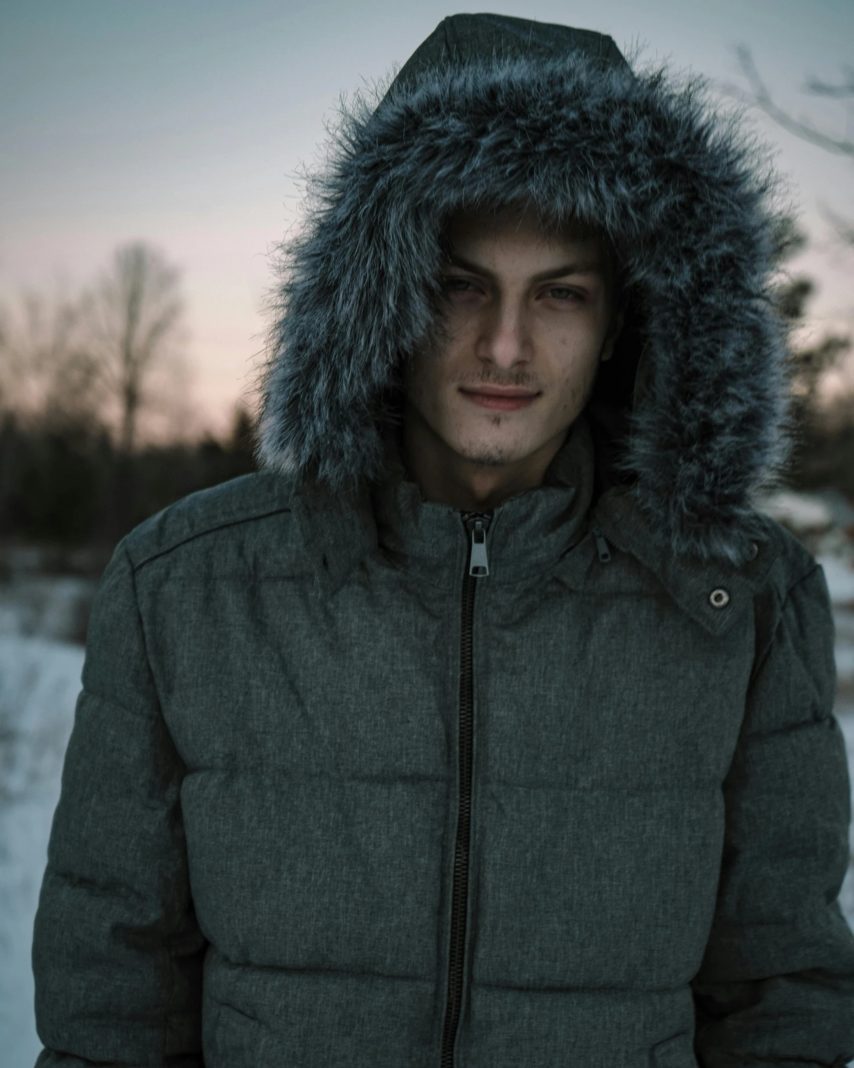 a man in a parka standing in the snow, inspired by Elsa Bleda, trending on pexels, renaissance, gray hoodie, non binary model, profile image, wearing a plug suit