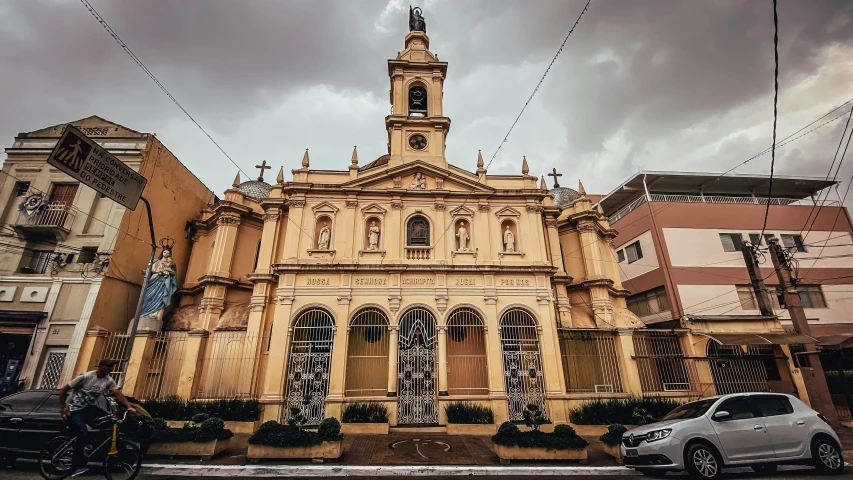 a car is parked in front of a church, by Alejandro Obregón, pexels contest winner, freddy mamani silvestre facade, neoclassical style, front side, brown