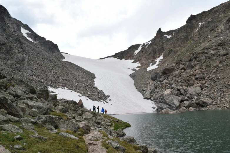 a group of people walking up the side of a mountain, a picture, ice snowy lake setting, devils horns, nordic summer, colorado