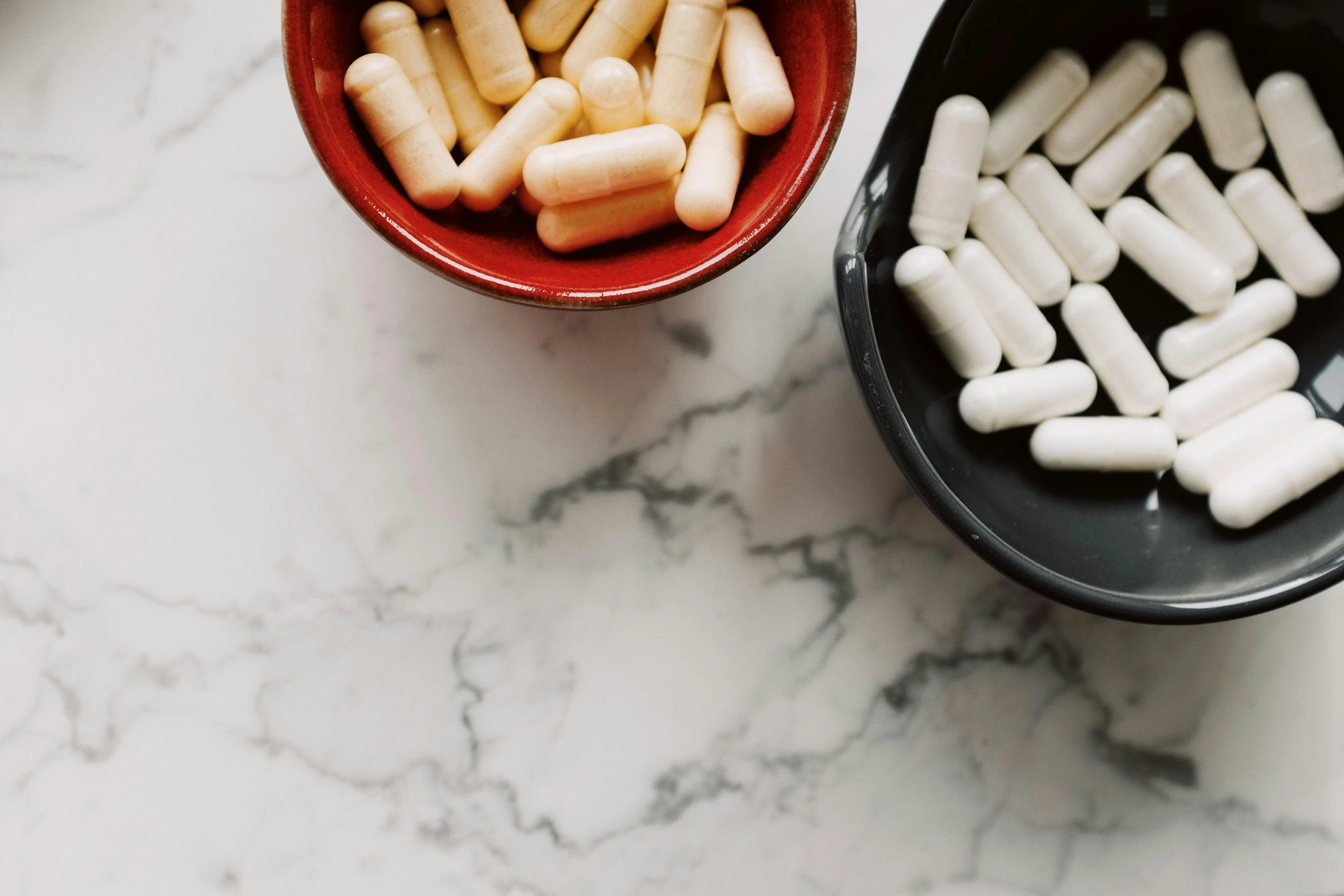 a couple of bowls filled with white pills, by Emma Andijewska, trending on pexels, marble countertops, retro stylised, ad image, lightening