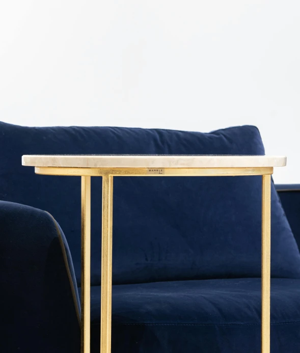 a blue couch sitting next to a table on top of a wooden floor, by William Home Lizars, white marble and gold, detailed product image, recognizable, product image