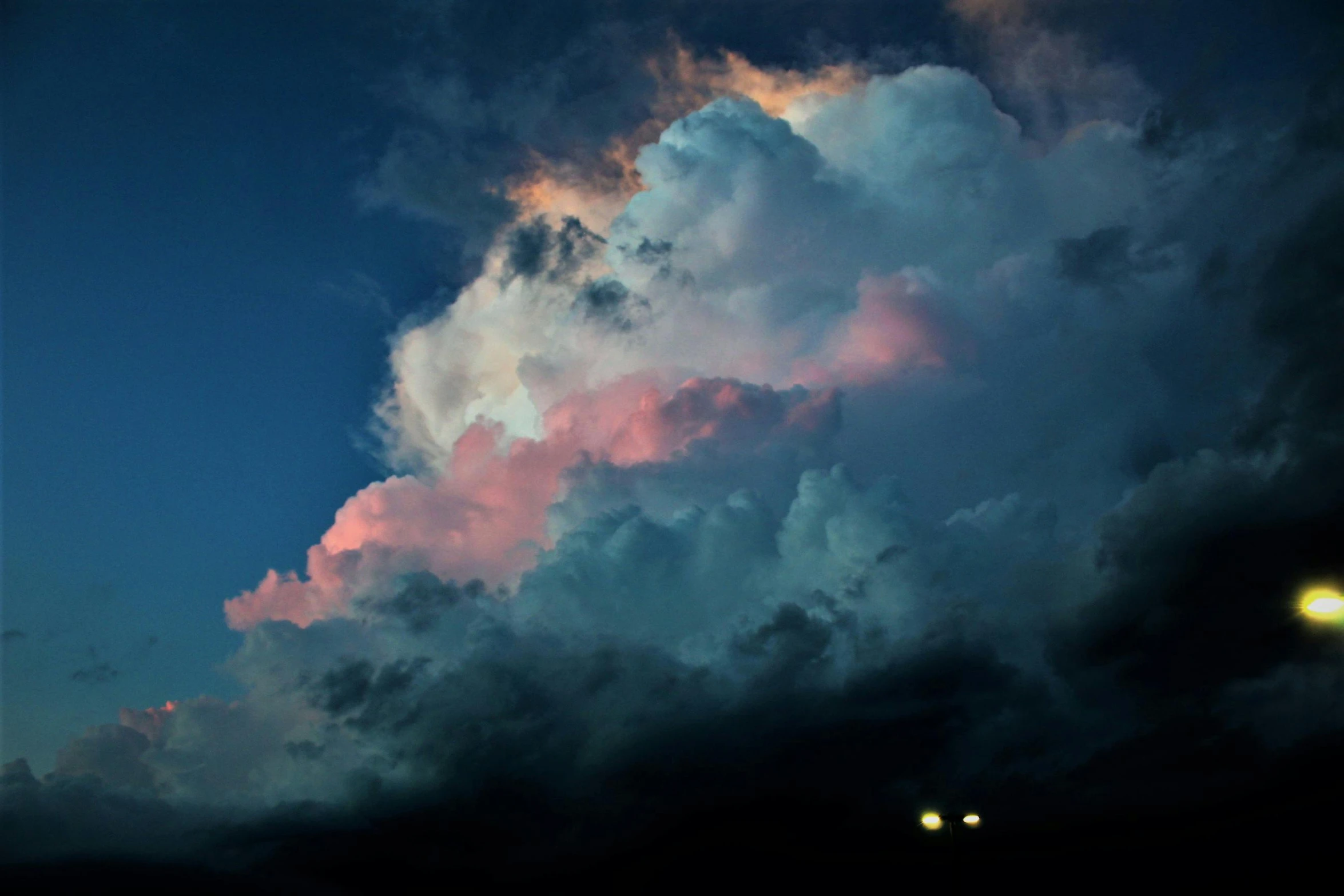 a large cloud that is in the sky, by Alison Geissler, unsplash contest winner, magical realism, blue and pink lighting, humid evening, lpoty, blue and orange lighting