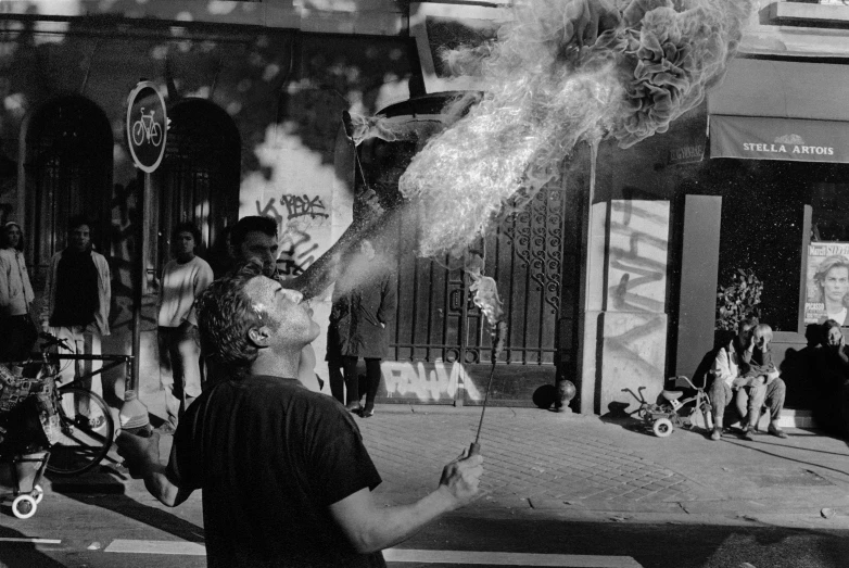 a black and white photo of a man holding a fire hydrant, a black and white photo, by Luis Molinari, street art, ayahuasca ceremony, smokey cannons, 1999 photograph, buenos aires