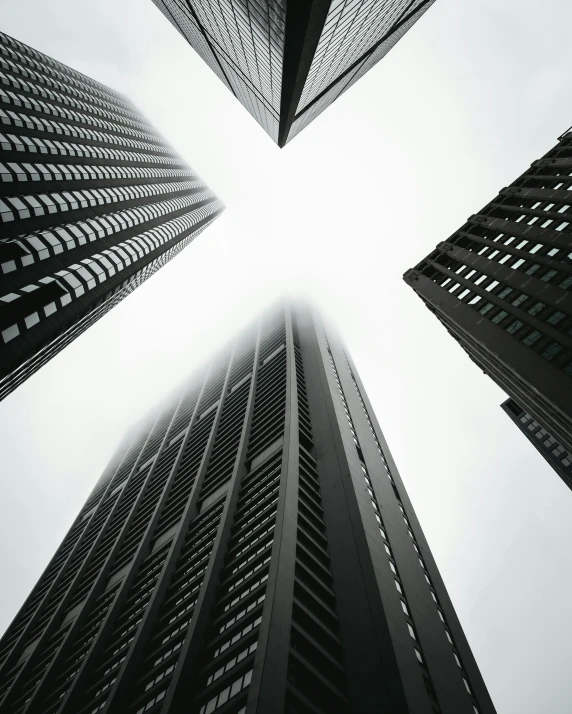 a black and white photo of tall buildings, pexels contest winner, ascending form the sky, three towers, tall minimalist skyscrapers, looking upwards