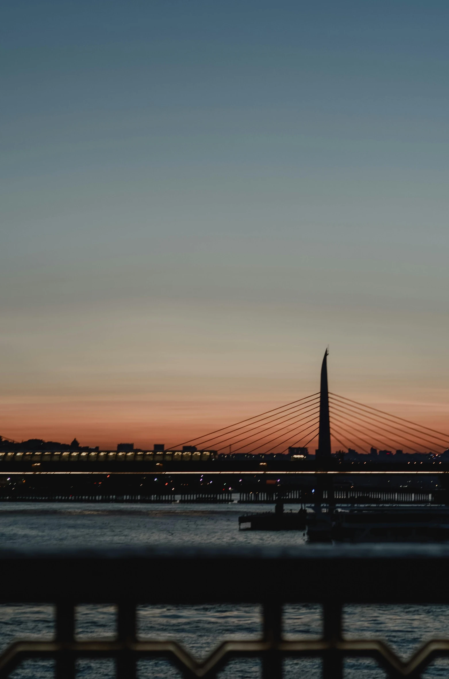 a bridge over a body of water at sunset, by Tamas Galambos, pexels contest winner, romanticism, rostov city, low quality photo, santiago calatrava, shot from a distance