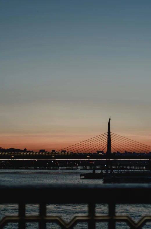 a bridge over a body of water at sunset, by Tamas Galambos, pexels contest winner, romanticism, rostov city, low quality photo, santiago calatrava, shot from a distance