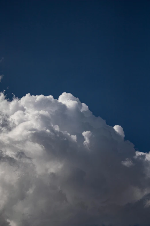 a jetliner flying through a cloudy blue sky, by Peter Churcher, giant cumulonimbus cloud, today\'s featured photograph 4k, up close, large white clouds