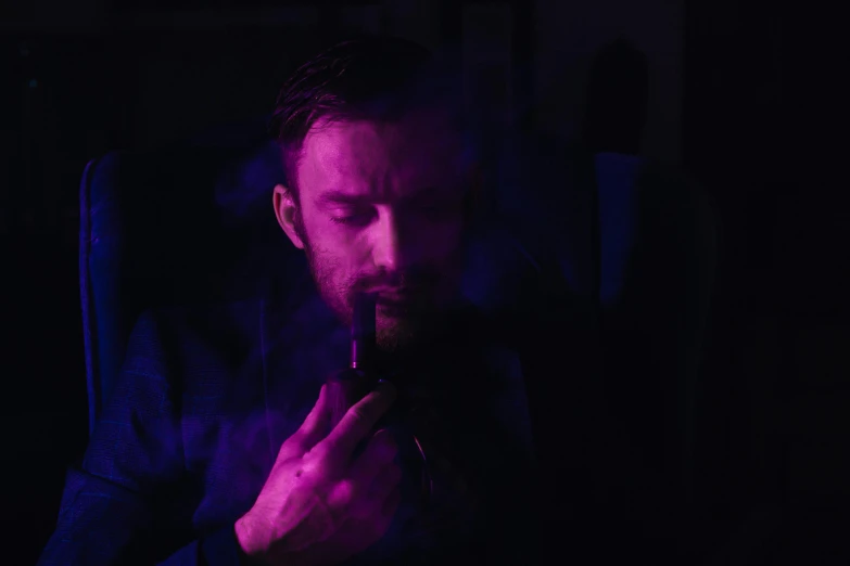 a man smoking a cigarette in a dark room, inspired by Vincent Lefevre, pexels contest winner, digital art, purple - tinted, charlie cox, blade runner 2049 lighting color, instagram post