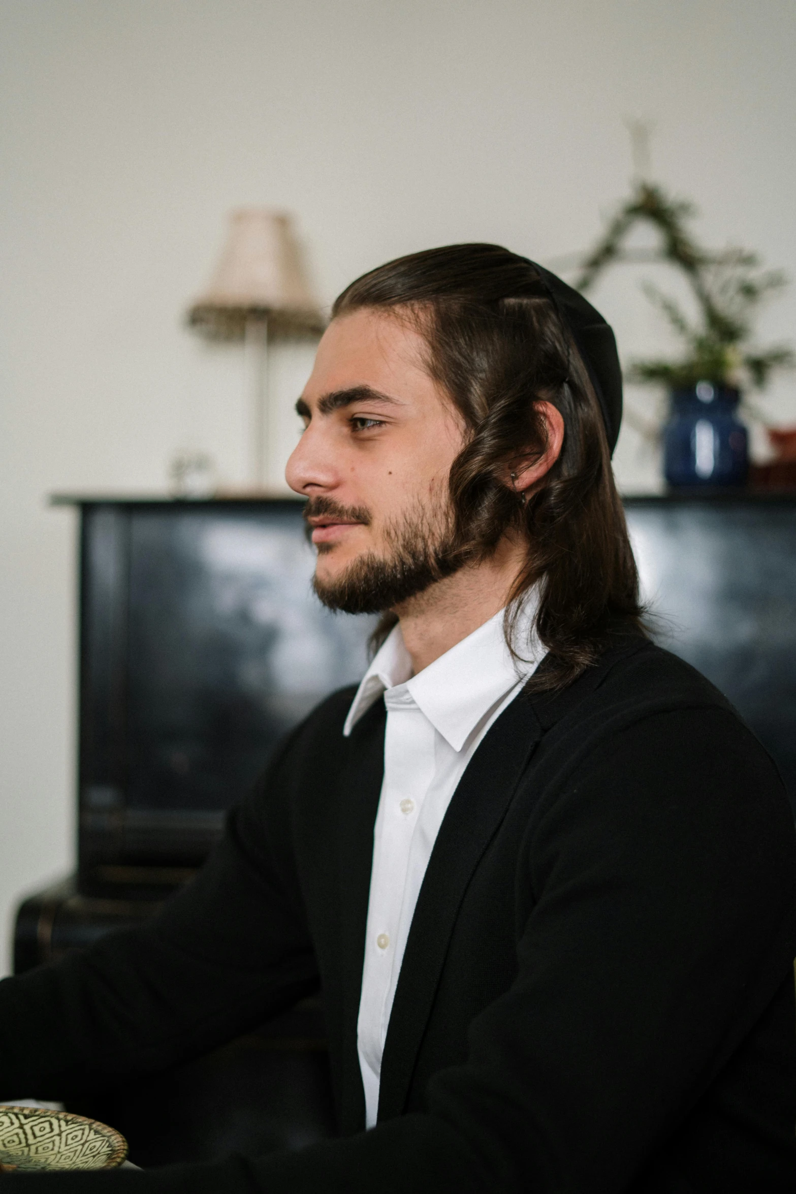 a man sitting in front of a laptop computer, an album cover, inspired by Thomas Mann Baynes, featured on reddit, renaissance, hair in slick low ponytail, mid long hair, hasan piker, headshot profile picture