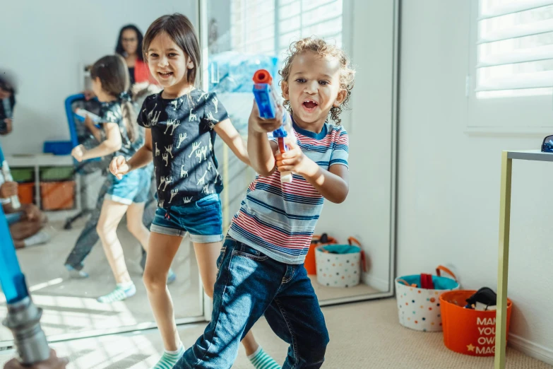 a group of children playing with water guns, a cartoon, pexels contest winner, indoor shot, avatar image, carrying guns, profile image