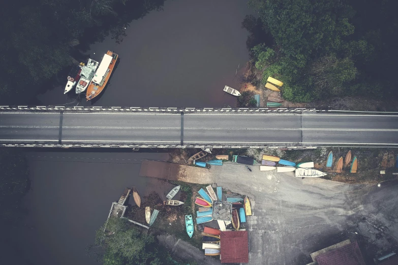 a group of boats sitting on top of a river next to a bridge, inspired by Filip Hodas, pexels contest winner, hurufiyya, malaysian, top - down perspective, worksafe. instagram photo, small town surrounding
