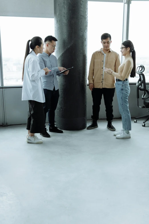 a group of people standing next to each other in a room, talking, concrete hitech interior, mid body shot, gen z