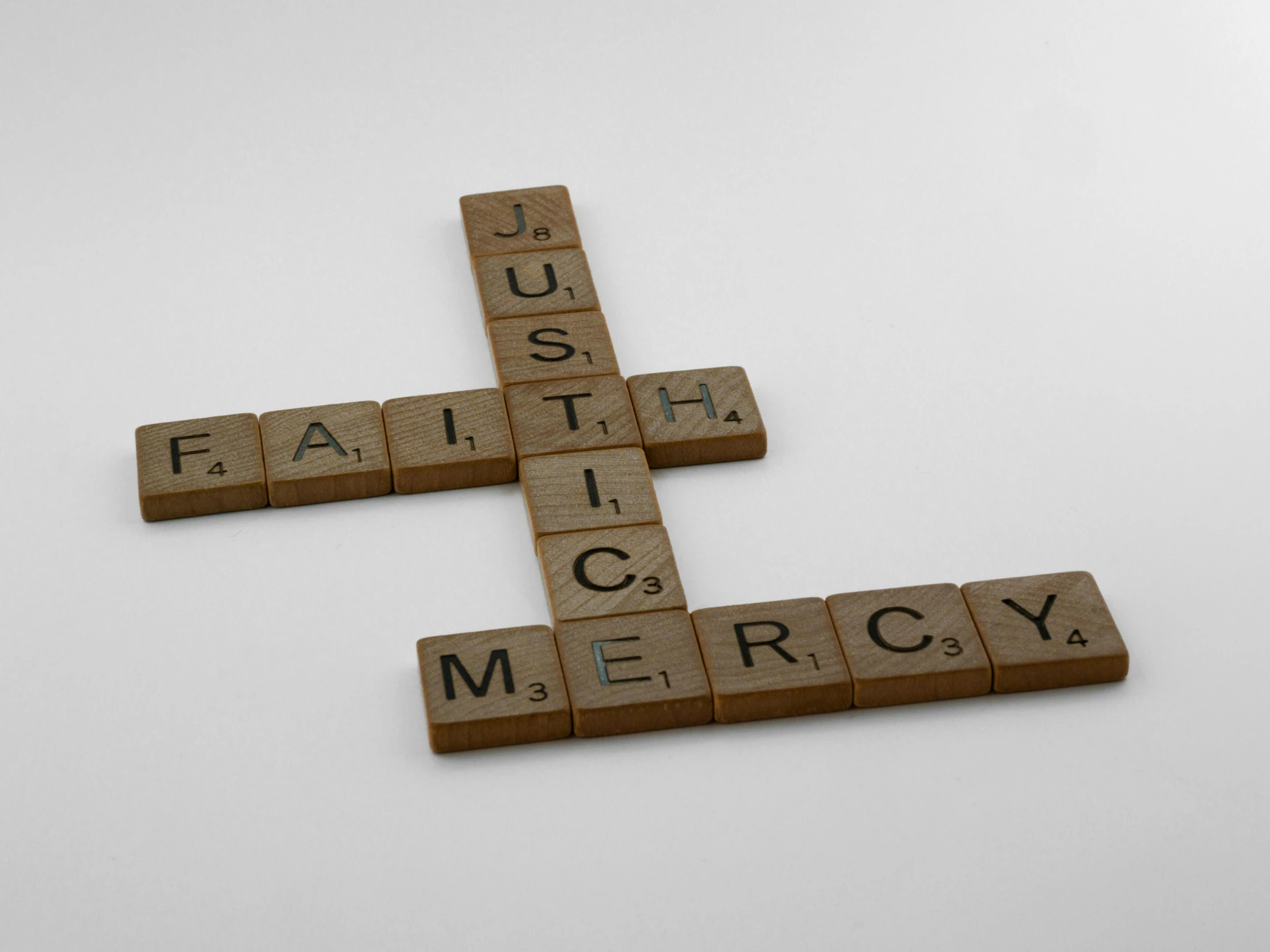 a cross made out of scrabbles sitting on top of a table, an album cover, by Jan Kupecký, hurufiyya, justice, splash image, mercury, faith