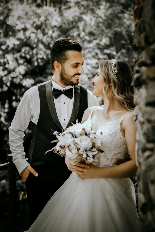 a bride and groom standing next to each other, pexels contest winner, attractive man, enhanced, looking off to the side, bouquet