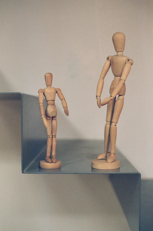 a couple of wooden figurines sitting on top of a shelf, inspired by Oskar Schlemmer, unsplash, hand on hips, walking to the right, anatomy, taken in the late 2010s