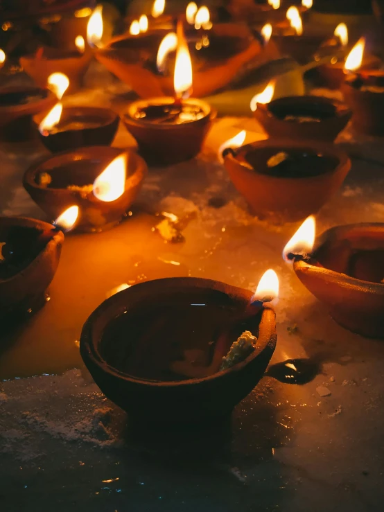 a group of candles sitting on top of a table, hindu aesthetic, promo image, multiple stories, made of glowing wax and ceramic