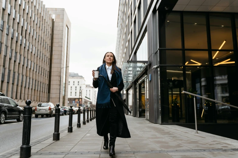 a woman walking down a city street talking on a cell phone, by Emma Andijewska, pexels contest winner, bauhaus, wearing business suit, long coat, handsome girl, thumbnail