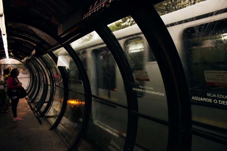 a subway train pulling into a station next to a platform, inspired by Nan Goldin, unsplash contest winner, transparent black windshield, curved, wet reflections, thumbnail