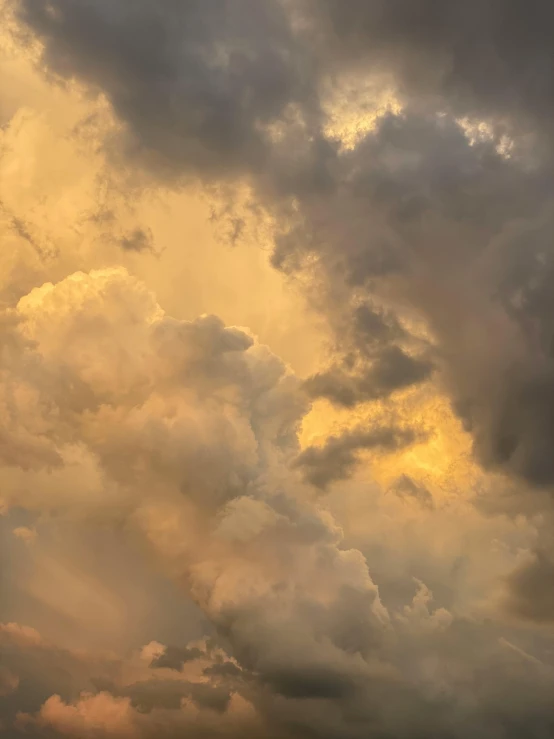 a plane is flying through a cloudy sky, by Neil Blevins, unsplash contest winner, romanticism, golden hues, today\'s featured photograph 4k, mammatus clouds, portrait photo