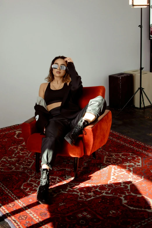 a woman sitting in a chair in a room, trending on pexels, wearing urban techwear, pokimane, velvet couch, asher duran