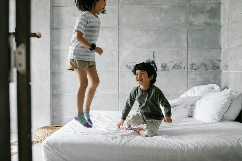 a couple of kids standing on top of a bed, pexels contest winner, happening, bouncing, easy to use, english, full-body