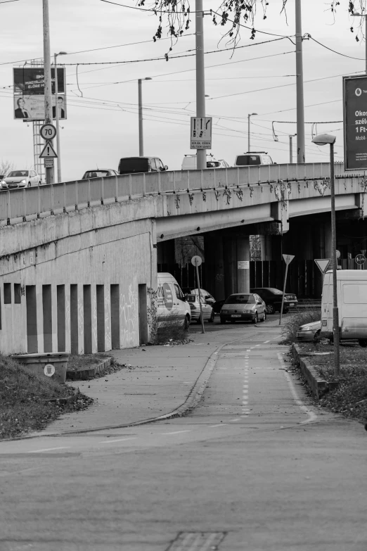 a black and white photo of a city street, a black and white photo, unsplash, graffiti, overpass, a ghetto in germany, highway, video still