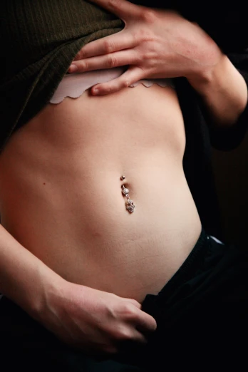 a woman with a tattoo on her stomach, inspired by Hedi Xandt, belly button showing, 2 point lights, plain background, bone jewellery