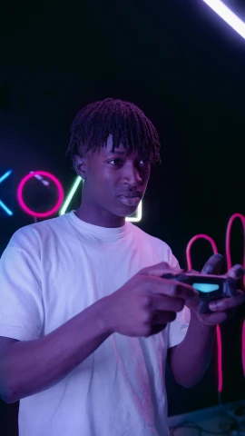 a man standing in front of a neon sign holding a cell phone, by Cosmo Alexander, trending on pexels, realism, black teenage boy, holding controller, cai xukun, color footage