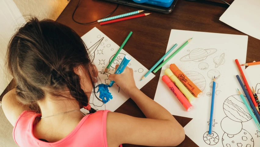 a little girl sitting at a table drawing with colored pencils, a child's drawing, by Julia Pishtar, pexels contest winner, neon coloring, colouring - in sheet, thumbnail, physical painting