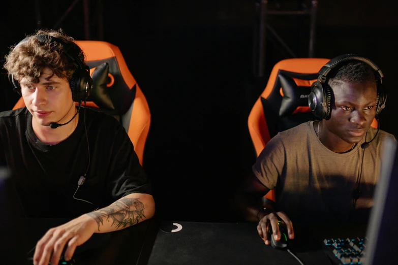 a couple of men sitting in front of a laptop computer, pexels, realism, wearing a gaming headset, black and orange, tournament, banner