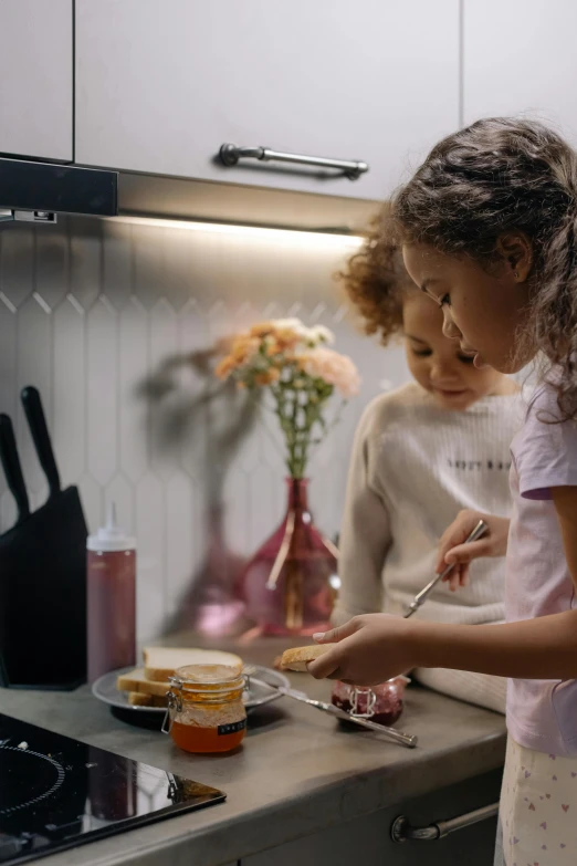 two little girls standing in a kitchen preparing food, a picture, by Adam Marczyński, pexels contest winner, led light strips, serving burgers, profile image, closeup - view