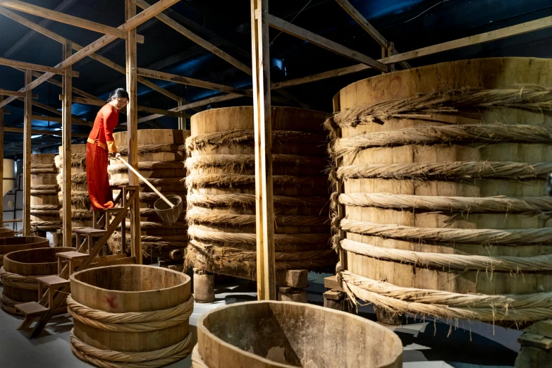 a man that is standing in front of a bunch of baskets, inside the building, churning, ruanjia, moonshine cybin