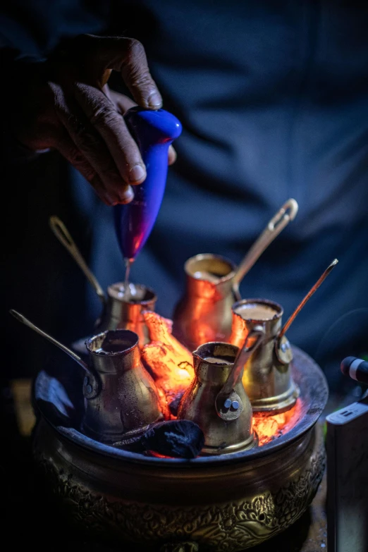 a close up of a person pouring something into a pot, by Jan Tengnagel, glowing lanterns, turkey, smoking vessels, brass and copper