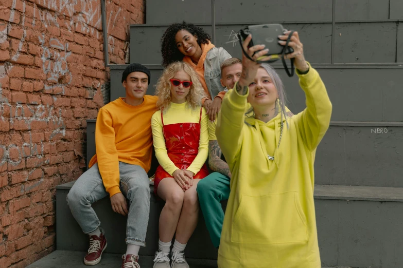 a group of people sitting on steps taking a selfie, trending on pexels, antipodeans, yellow and red, woman in streetwear, avatar image, sergey krasovskiy