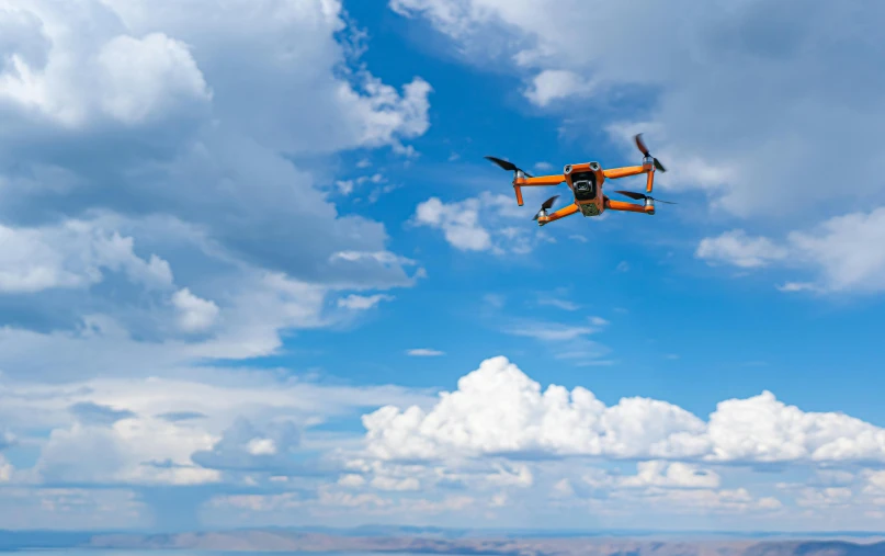 a small orange drone flying in the sky, a digital rendering, unsplash, square, thumbnail, big sky, 2030