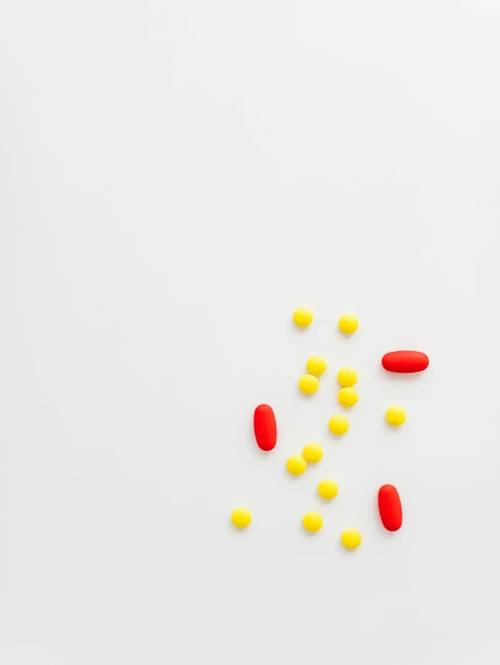 red and yellow pills on a white surface, by Emma Andijewska, minimalism, ad image, medic, f 1, soft